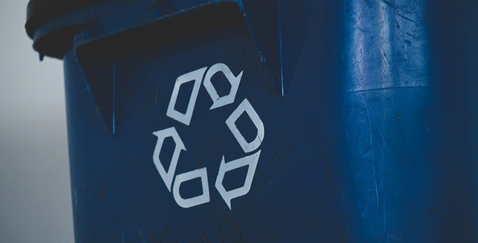 Logo recycler sur un bac en plastique bleu